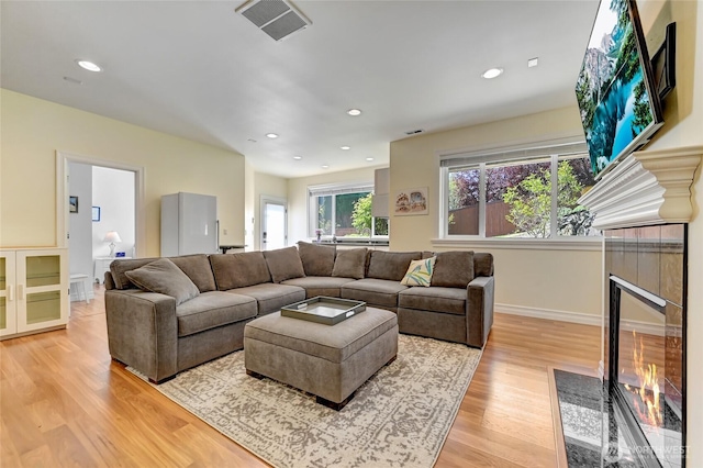 living area with light wood finished floors, a fireplace, recessed lighting, baseboards, and visible vents