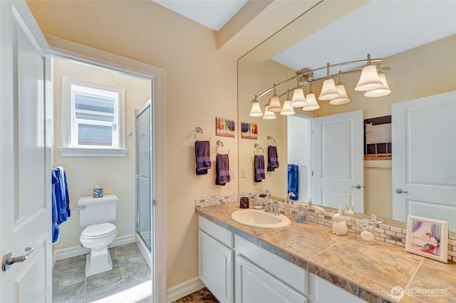 bathroom featuring vanity, baseboards, toilet, and a shower stall