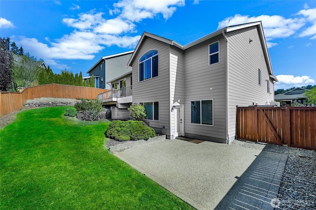 back of property featuring a patio, a fenced backyard, and a lawn