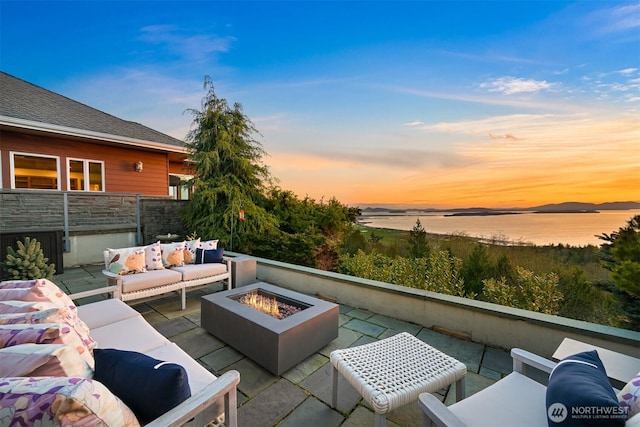 view of patio with an outdoor living space with a fire pit