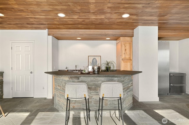 bar with recessed lighting, baseboards, wooden ceiling, and indoor wet bar