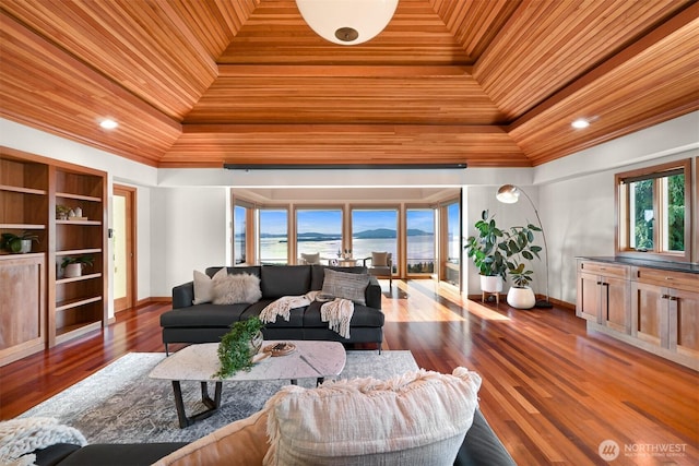 living room with wood finished floors, a water view, wooden ceiling, crown molding, and baseboards