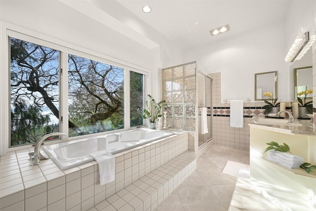 full bath with a garden tub, tile patterned floors, a stall shower, vanity, and tile walls