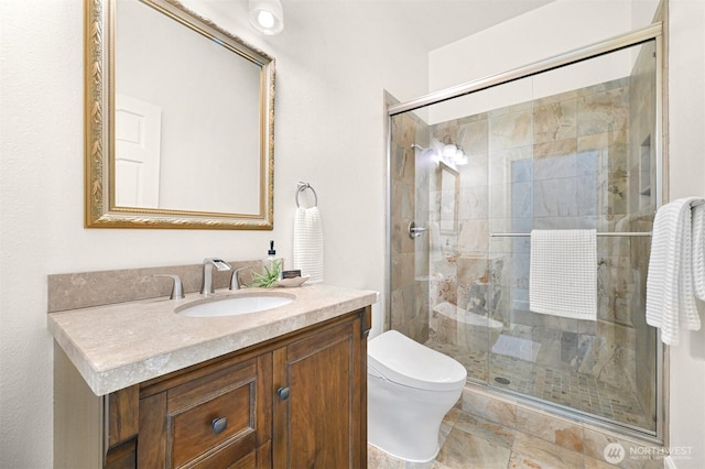 full bath with toilet, vanity, and a stall shower