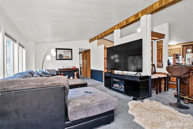 carpeted living area featuring lofted ceiling with beams and a fireplace