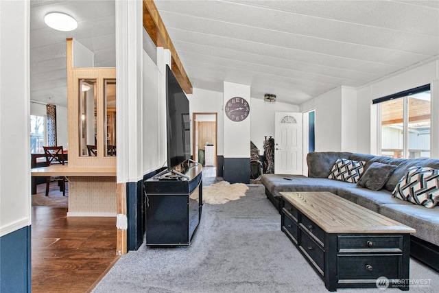 living area featuring baseboards, vaulted ceiling, and wood finished floors