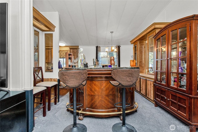 bar with indoor bar, a notable chandelier, pendant lighting, and carpet