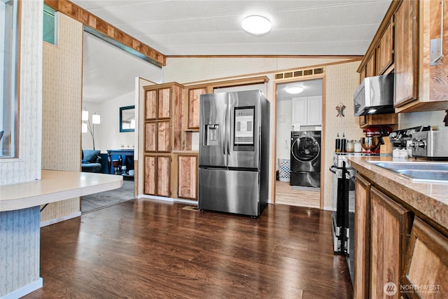 kitchen with dark wood-style flooring, stainless steel fridge with ice dispenser, washer / dryer, vaulted ceiling with beams, and wallpapered walls