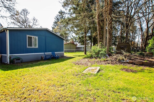 view of yard featuring fence, a storage unit, and an outdoor structure