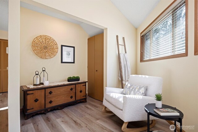 sitting room with vaulted ceiling and light wood-style floors