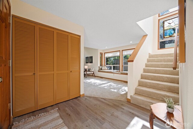 entryway featuring wood finished floors, stairs, and baseboards