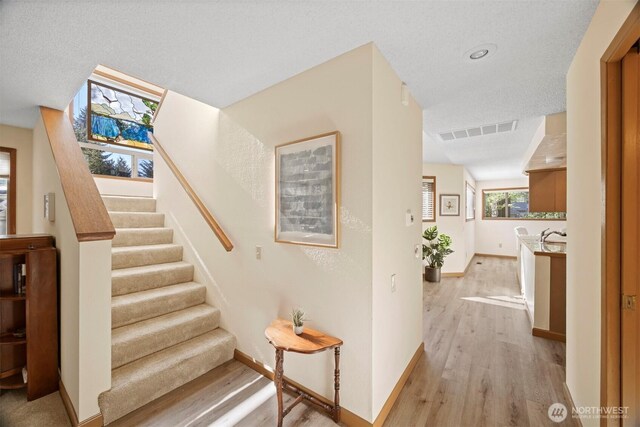 stairway featuring wood finished floors and baseboards