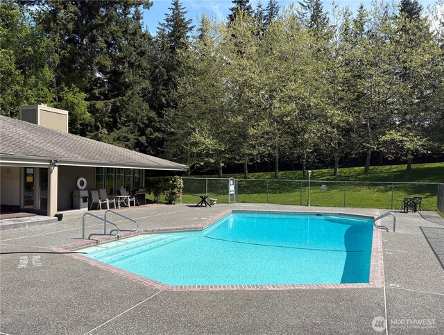 view of swimming pool with a patio area and fence