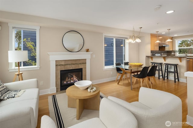 living area with recessed lighting, light wood-style flooring, and a fireplace