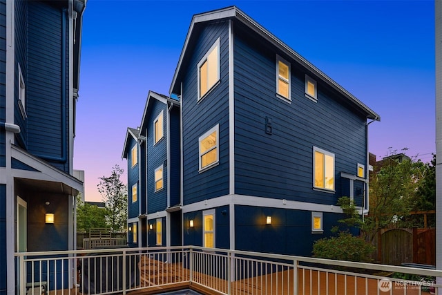property exterior at dusk featuring fence