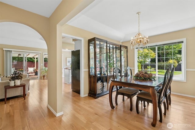10116 SE 188th St, Renton, WA 98055 - dining area featuring a chandelier, light wood-style flooring, arched walkways, and baseboards
