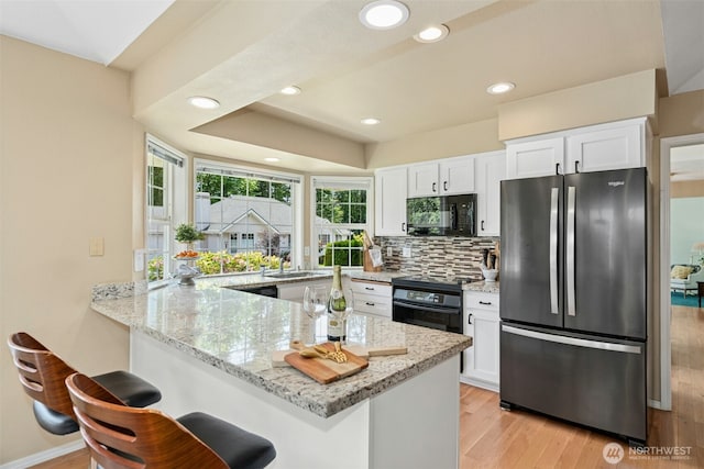 10116 SE 188th St, Renton, WA 98055 - kitchen featuring black appliances, white cabinetry, light stone counters, and recessed lighting