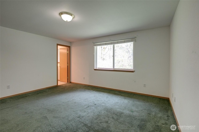 spare room with baseboards and carpet