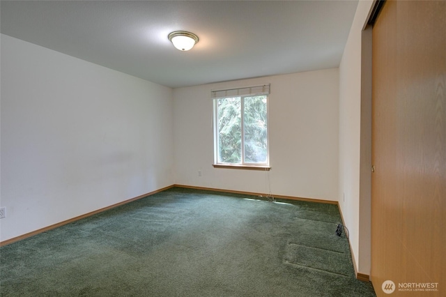 carpeted spare room featuring baseboards
