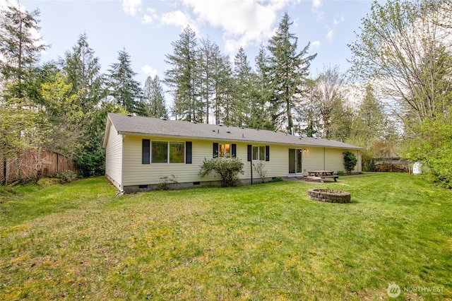 back of house with a lawn, crawl space, an outdoor fire pit, and fence