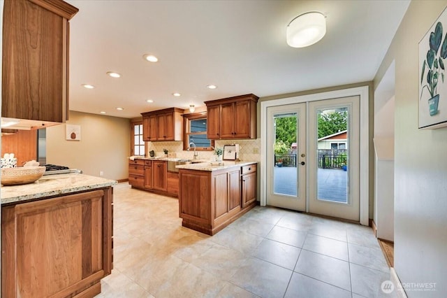kitchen featuring tasteful backsplash, brown cabinets, french doors, plenty of natural light, and recessed lighting