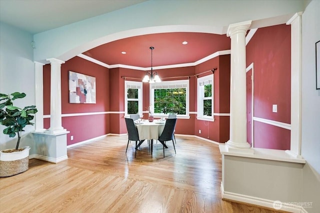 dining space featuring ornate columns, wood finished floors, baseboards, recessed lighting, and crown molding