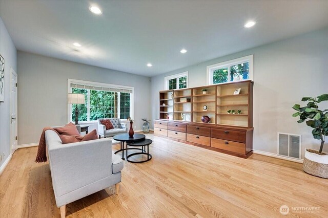 living area with light wood-style flooring, plenty of natural light, baseboards, and recessed lighting
