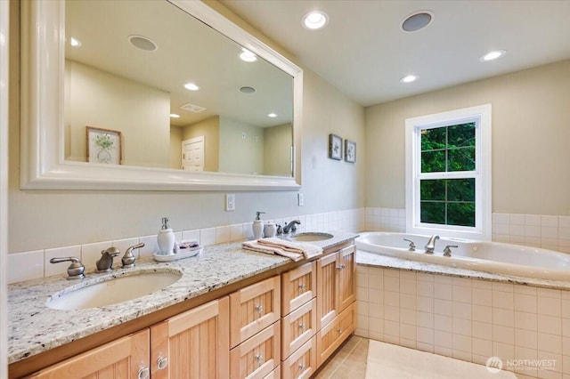 bathroom featuring a garden tub, tile patterned floors, recessed lighting, and double vanity