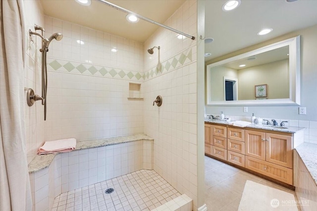 bathroom with tile patterned floors, a tile shower, recessed lighting, and double vanity