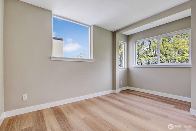 unfurnished room featuring baseboards and wood finished floors