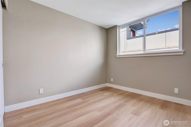 spare room featuring baseboards and wood finished floors