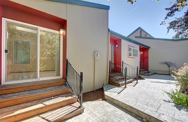 view of exterior entry with a patio