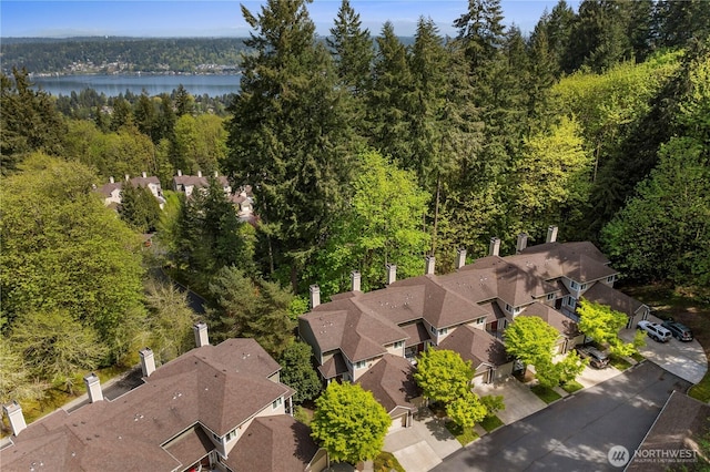 bird's eye view with a water view and a wooded view