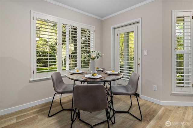 dining space featuring crown molding, baseboards, and wood finished floors