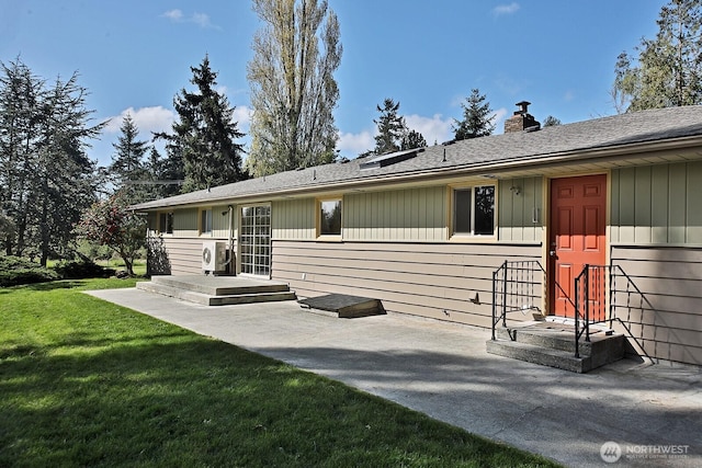 view of front of house with a patio area, a chimney, a front yard, and a shingled roof