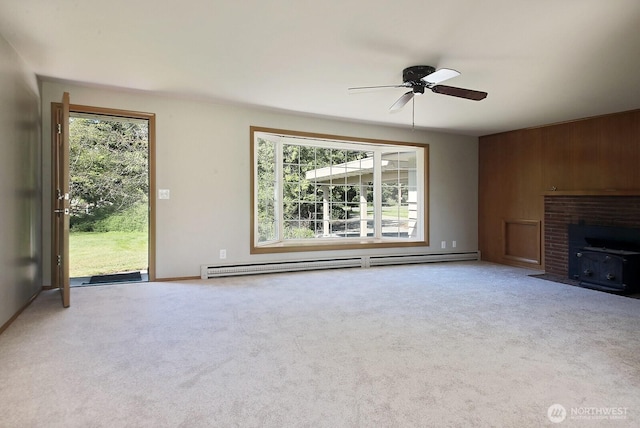 unfurnished living room featuring a baseboard heating unit, plenty of natural light, carpet floors, and ceiling fan