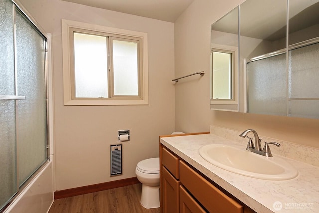 bathroom with wood finished floors, vanity, enclosed tub / shower combo, toilet, and visible vents