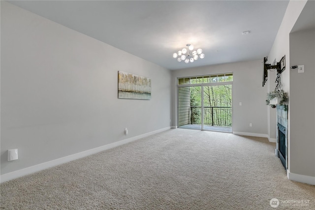 15700 116th Ave NE Unit 205, Bothell, WA 98011 - unfurnished room with a fireplace, baseboards, light carpet, and an inviting chandelier