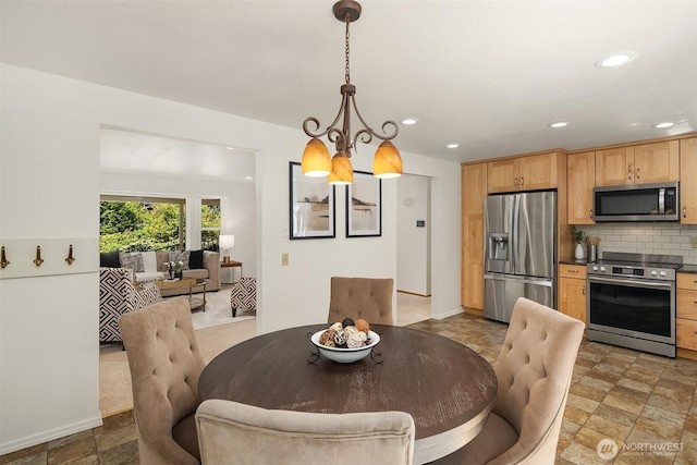 dining space with stone finish floor, recessed lighting, and a chandelier