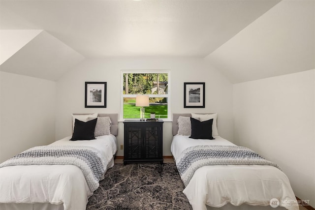 bedroom with wood finished floors and lofted ceiling