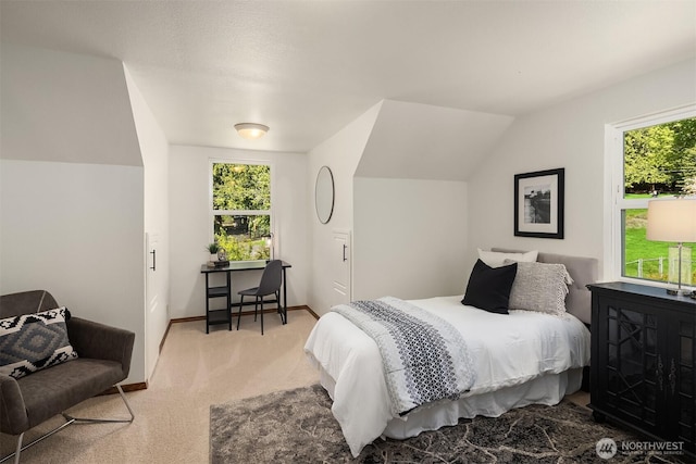 bedroom featuring light colored carpet, baseboards, lofted ceiling, and multiple windows