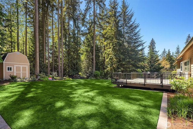 view of yard with a storage shed, a wooden deck, and an outdoor structure