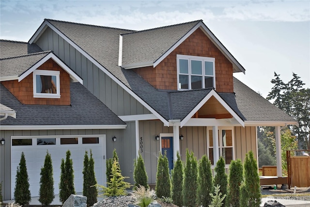 craftsman house with an attached garage, board and batten siding, and a shingled roof