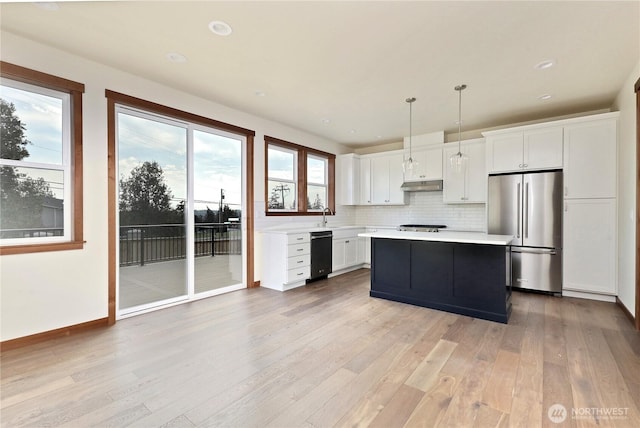 kitchen with light wood-style floors, black dishwasher, light countertops, and freestanding refrigerator