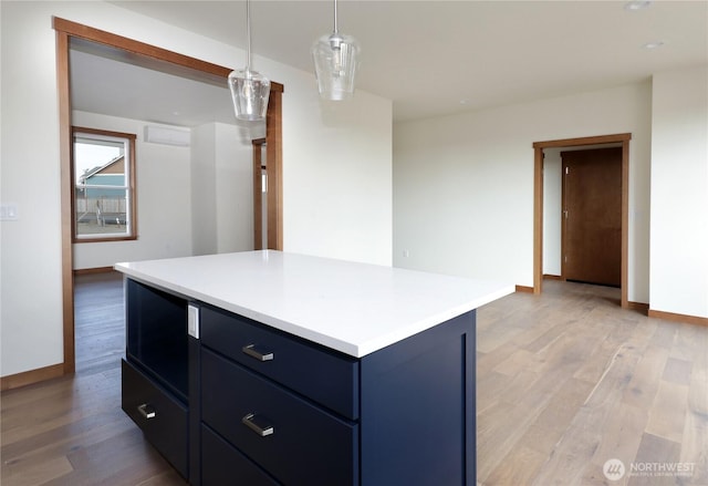 kitchen with light wood finished floors, light countertops, and baseboards