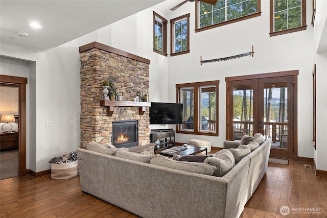 living room featuring baseboards, a ceiling fan, french doors, and hardwood / wood-style flooring