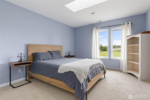 bedroom with a skylight, baseboards, carpet flooring, and visible vents