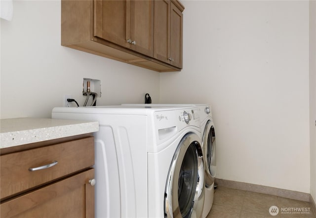 laundry area with light tile patterned floors, baseboards, cabinet space, and independent washer and dryer