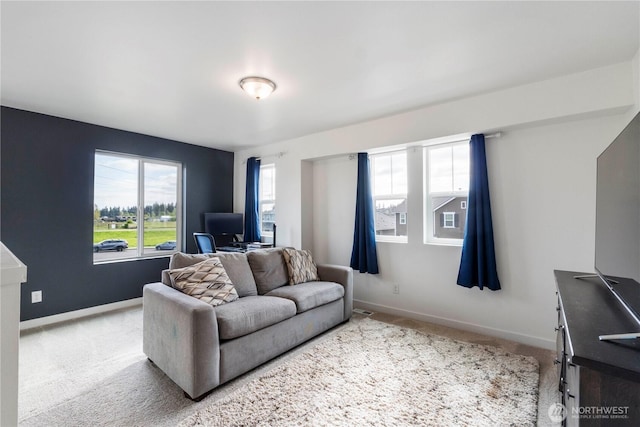 carpeted living area featuring baseboards