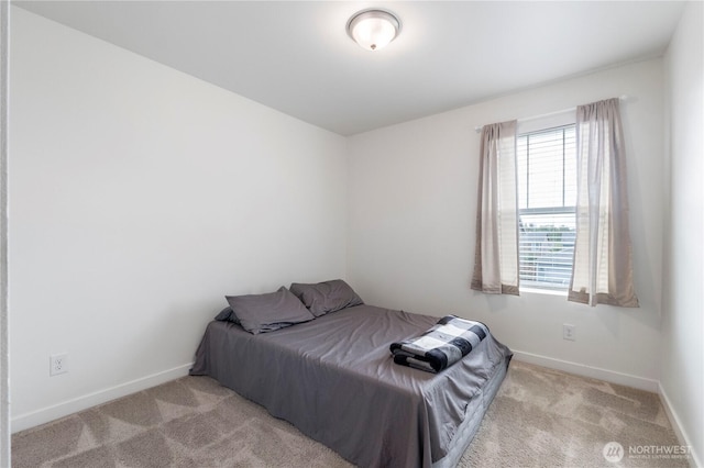 bedroom featuring baseboards and carpet